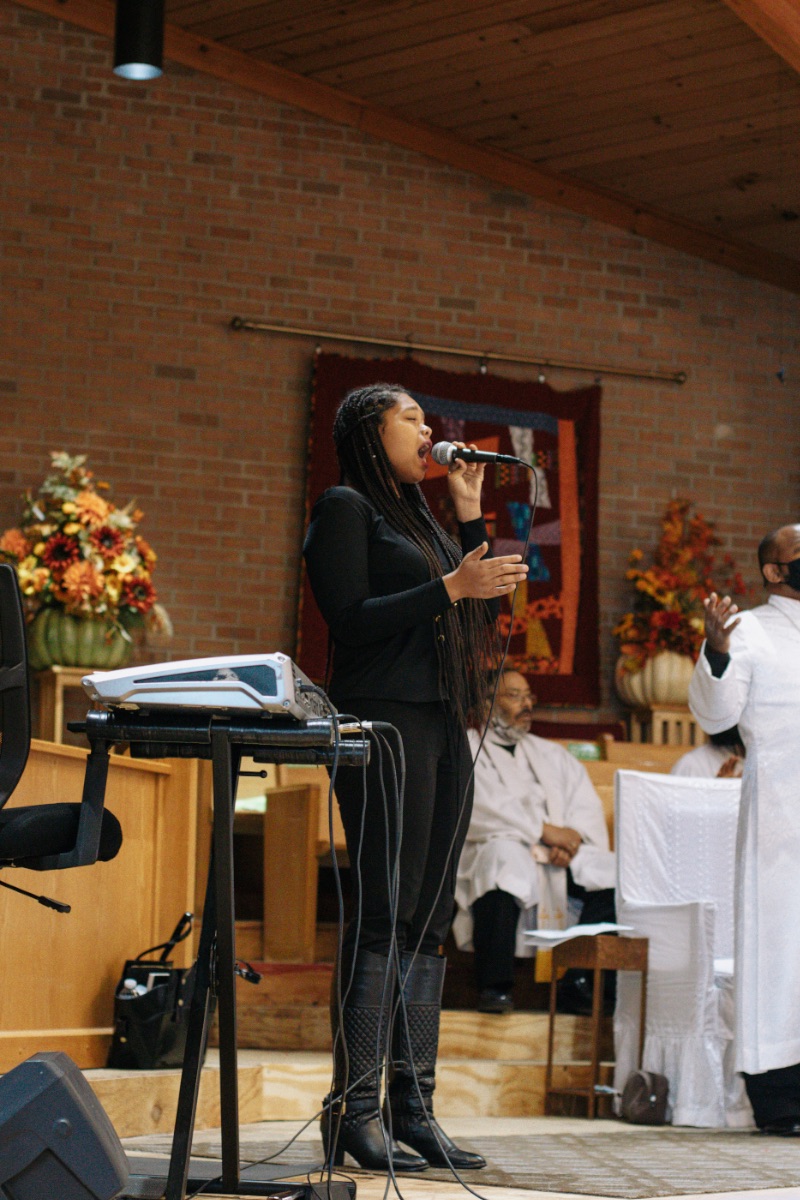 Nicole singing into a microphone, leading worship at Bethel in Morristown